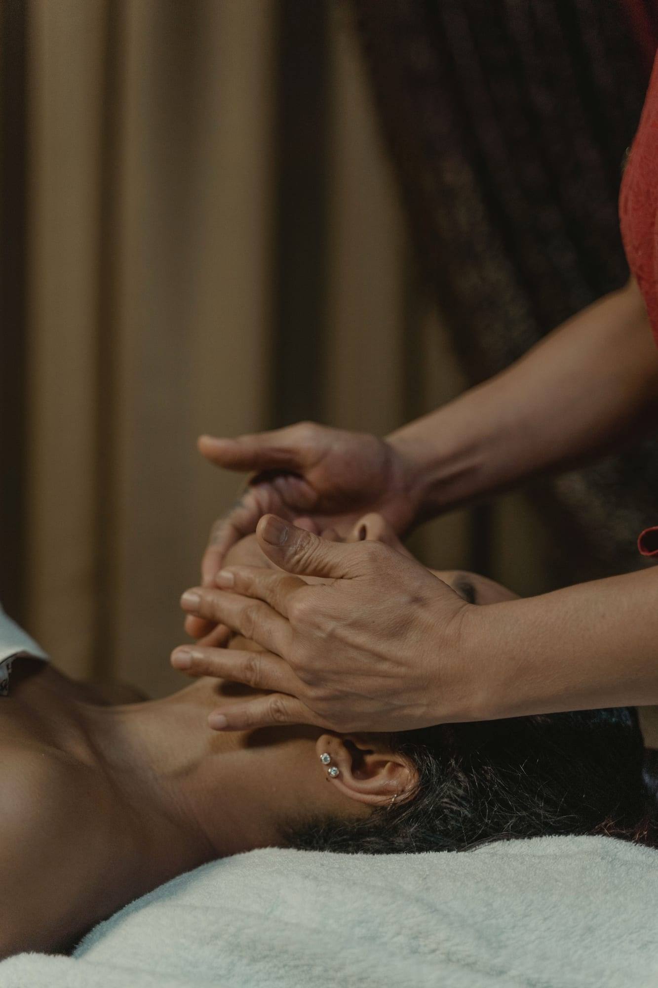 Uzanan birine nazik bir yüz masajı yapan eller